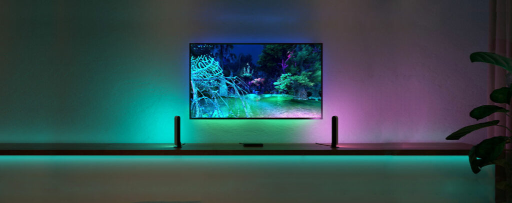 Wall-mounted TV with coloured lights via phiips hue lighting system