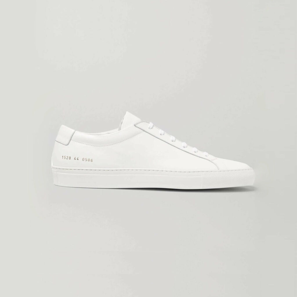 white low top leather sneakers side profile on a grey background